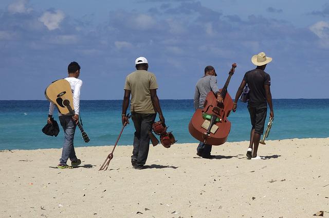 Musiker einer Band laufen am Strand entlang