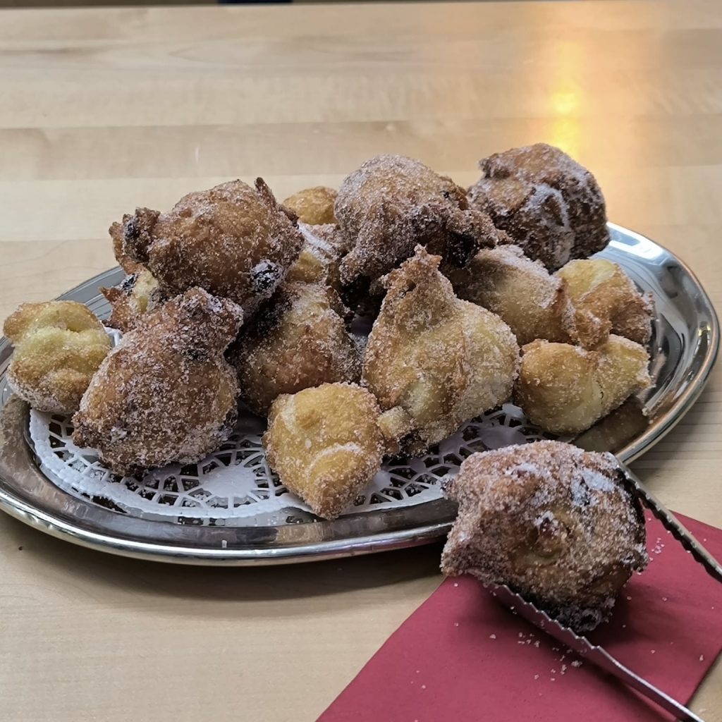 Auf einer silbernen Platte werden Krapfen serviert